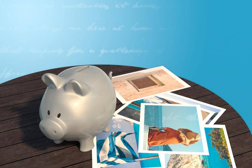 A piggy bank on top of travel pictures 