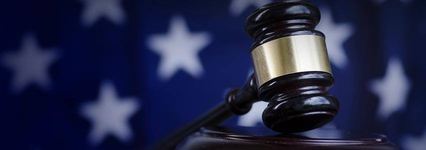A gavel on a book in front of the US flag