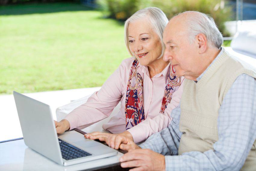 An elderly couple looking at a computer together