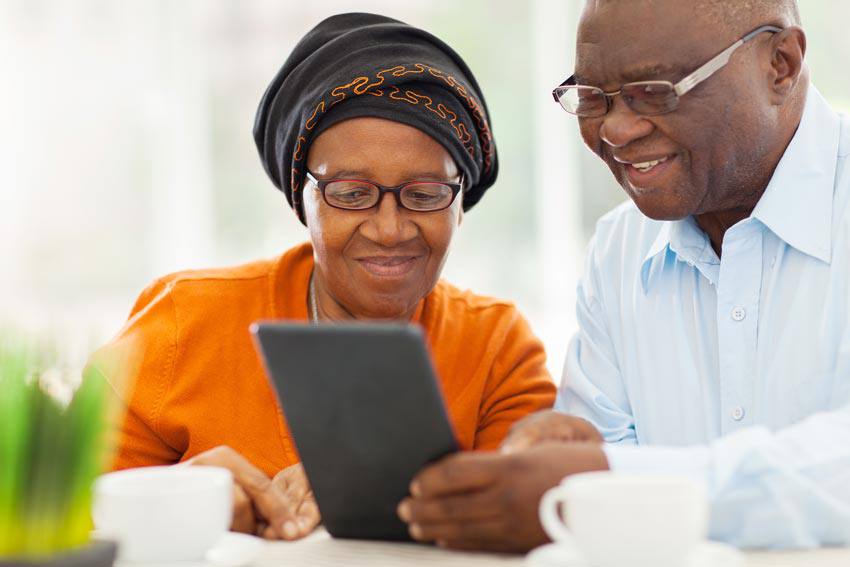 A couiple using their tablet while drinking coffee
