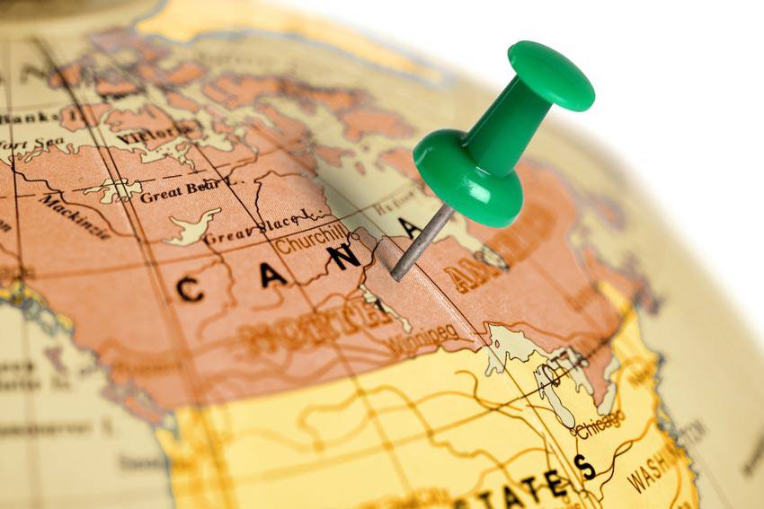 A globe with a thumbtack on Canada