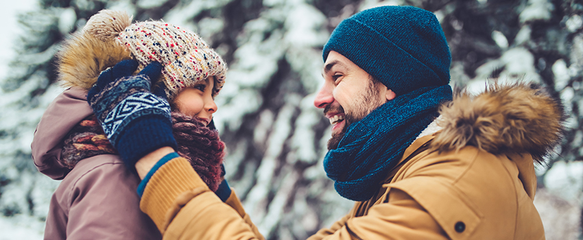 A man and his daughter smiling in winter