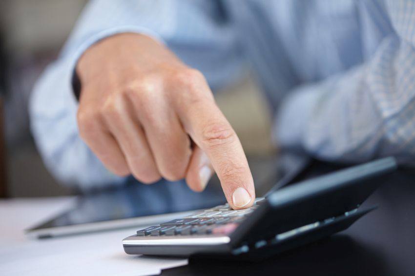 A person calculating numbers with a calculator
