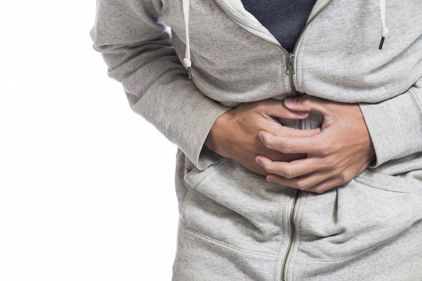 A man holding his stomach with his hands from pain