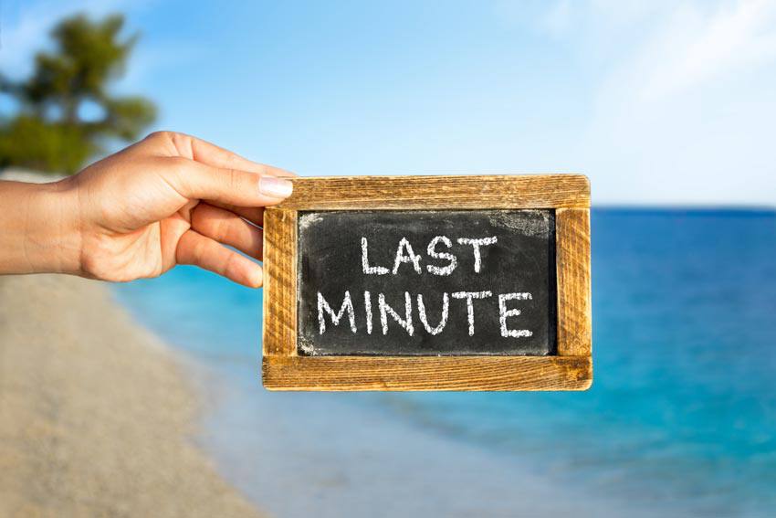 A black chalkboard at a beach written "Last minute" on it 