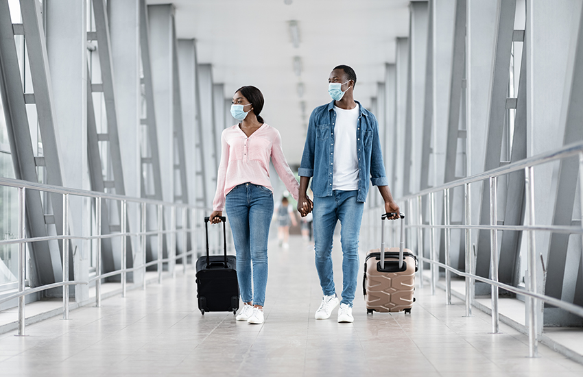 A couple walking in the airport with their luggage