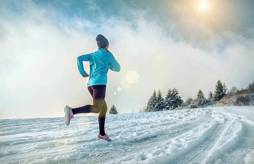 A woman running in a field of snow