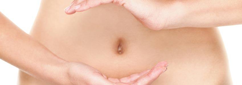 A person's stomach with their hands around the belly button