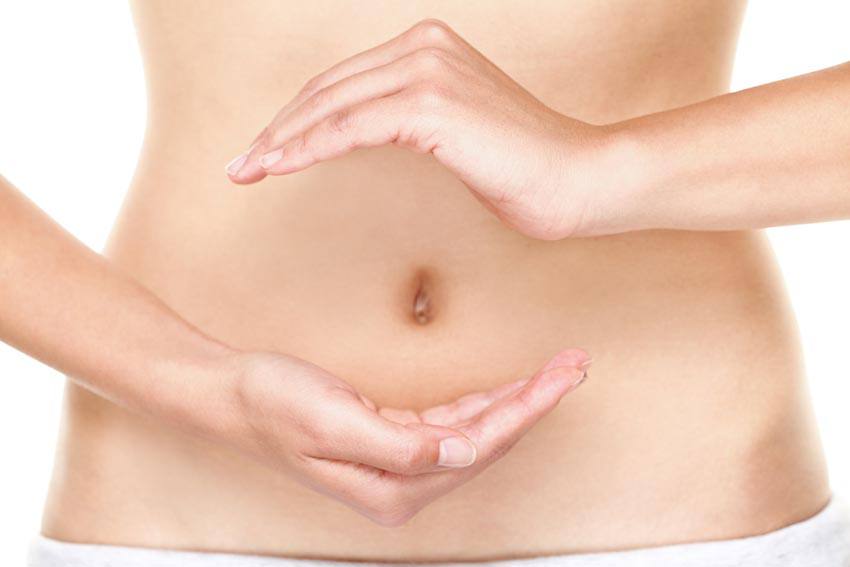 A person's stomach with their hands around the belly button