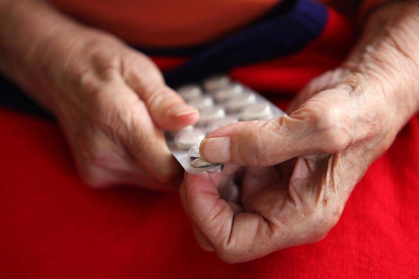 An old person taking pills