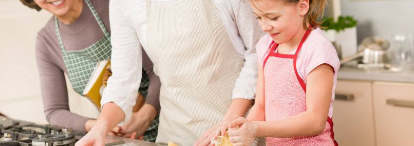 A family helping the daughter cook with dough 