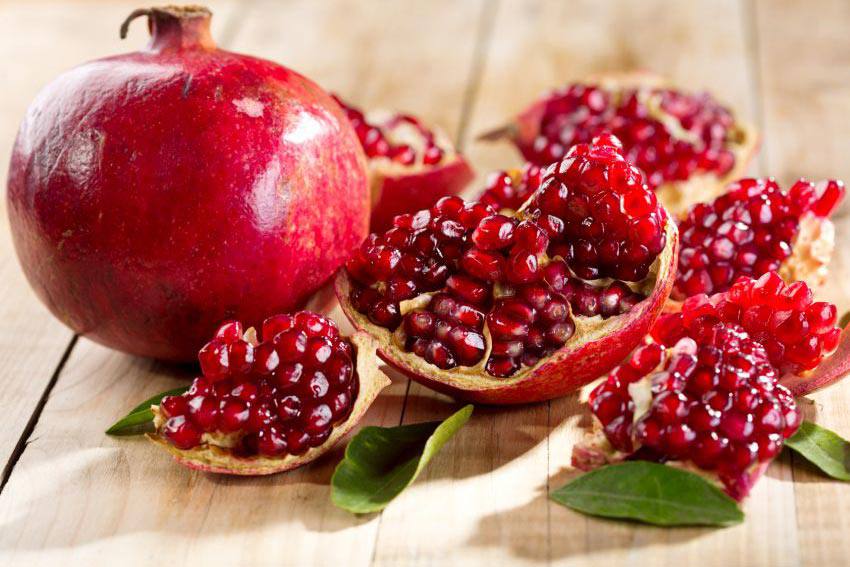 An open pomegrenate beside an intact one