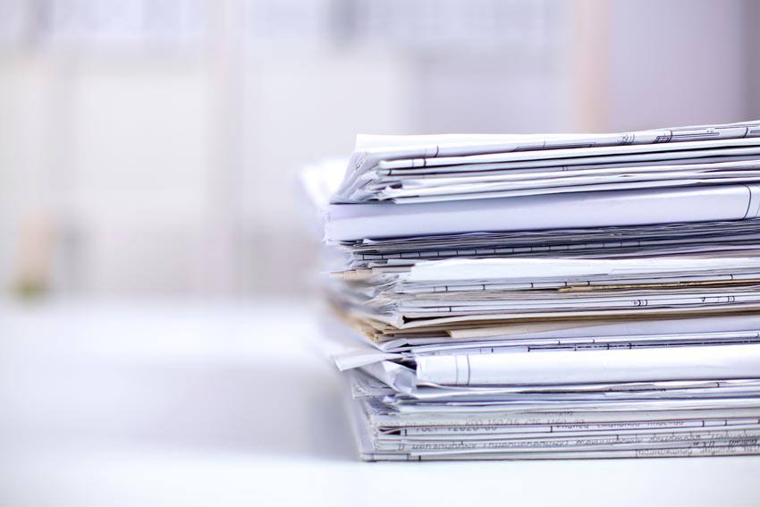 A pile of documents on top of a desk