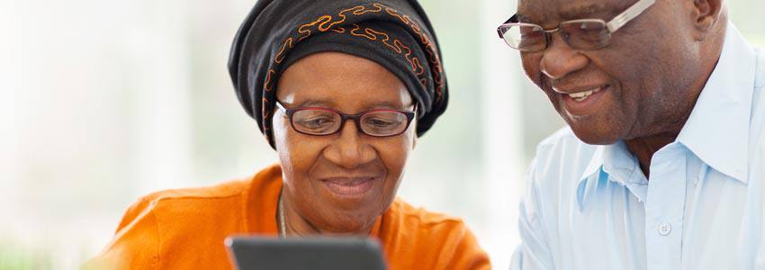 A couiple using their tablet while drinking coffee