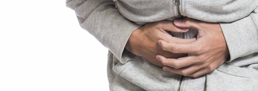 A man holding his stomach with his hands from pain