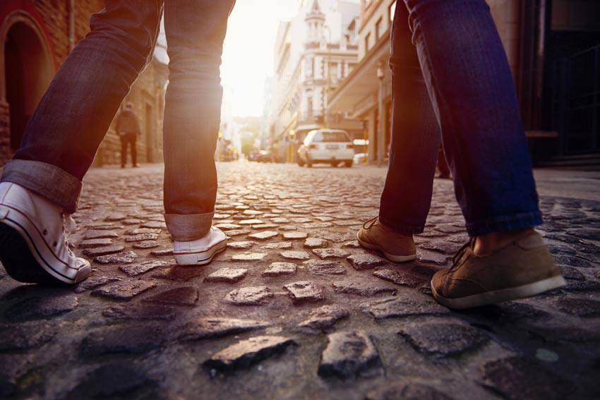 Two people walking in the middle of a street 
