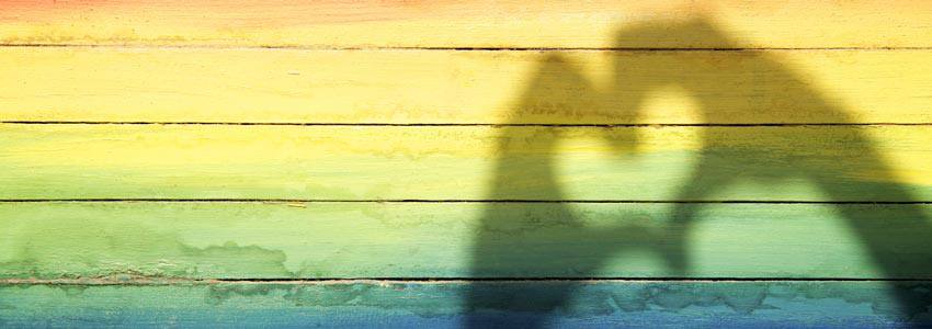 The pride flag with a shadow hand heart 