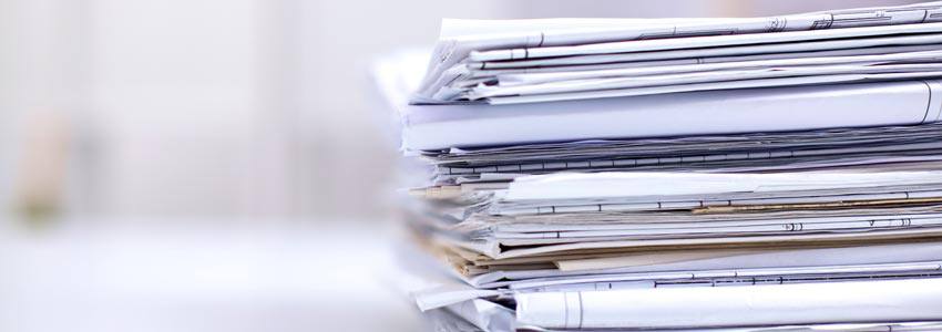 A pile of documents on top of a desk