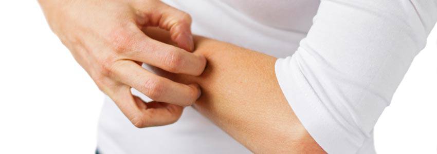 A person scratching their forearm 
