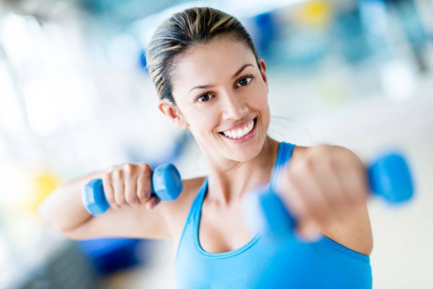 A woman working out with two small weights 