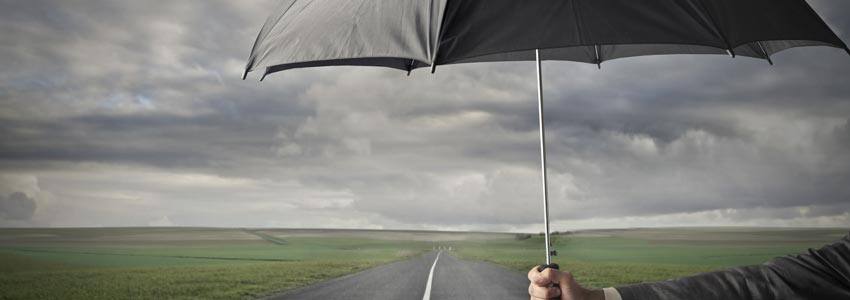 A person holding an umbrella under a cloudy sky