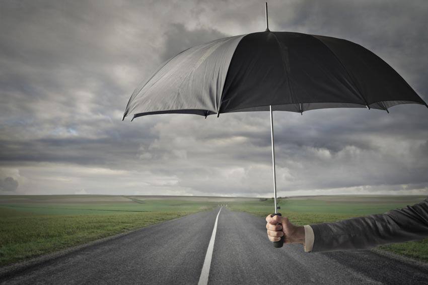A person holding an umbrella under a cloudy sky