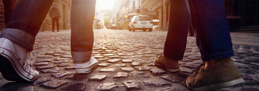 Two people walking in the middle of a street 