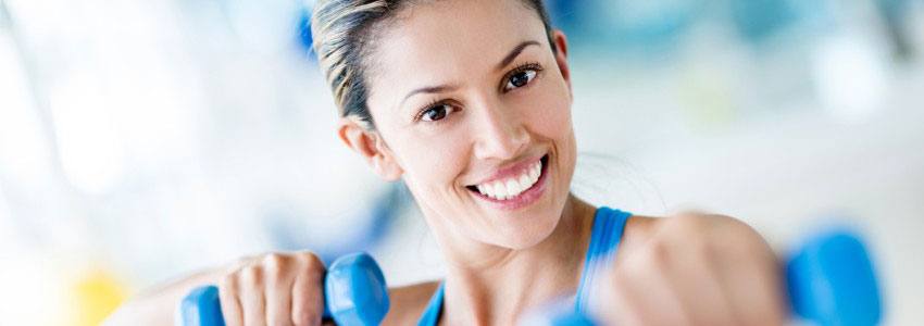 A woman working out with two small weights 