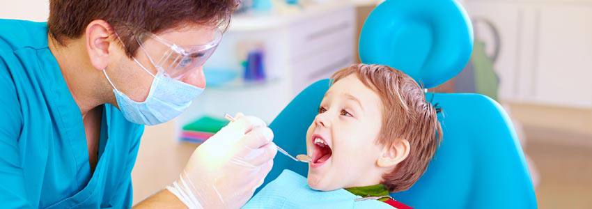 A child at the dentist laying down beside his dentist