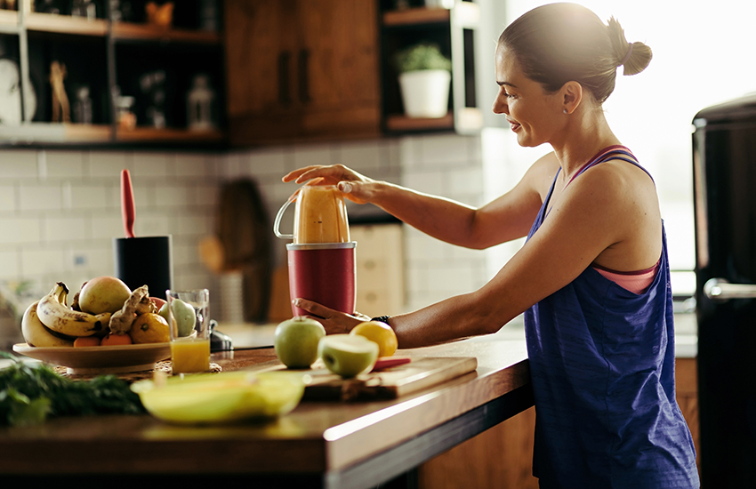A woman making a shake in a blender