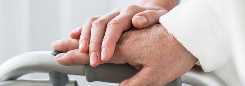 An elderly person holding a support with someone else