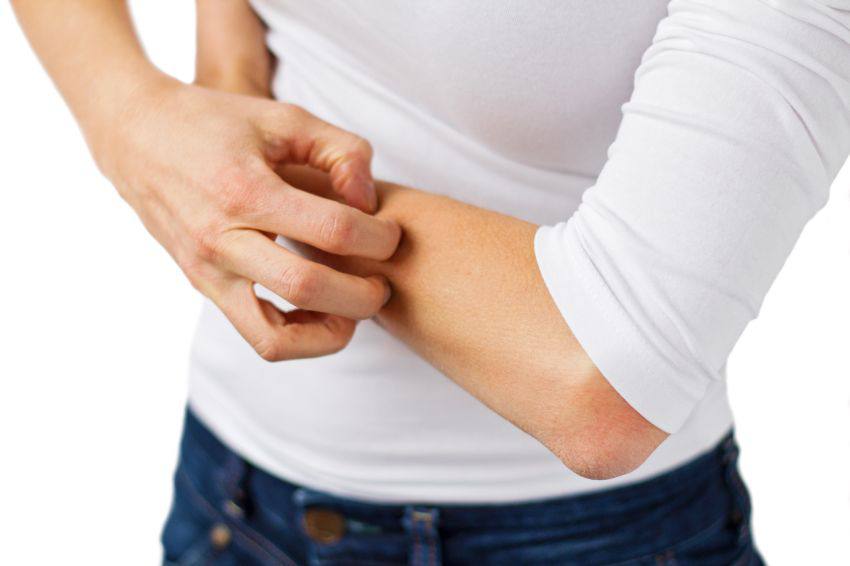 A person scratching their forearm