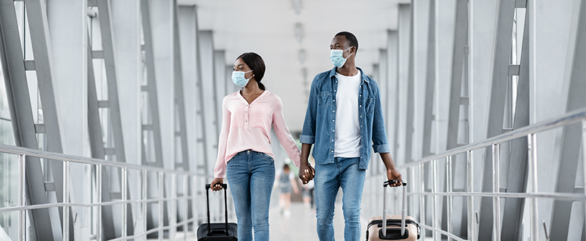 A couple walking in the airport with their luggage
