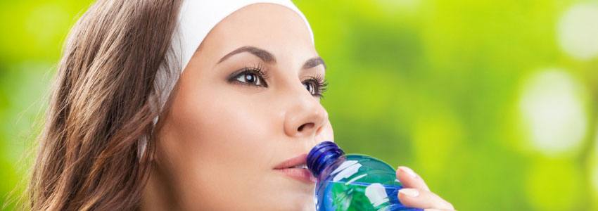A woman drinking water in a hot summer