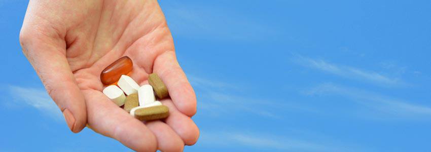 A hand full of pills with different colours