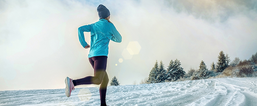 A woman running in a field of snow