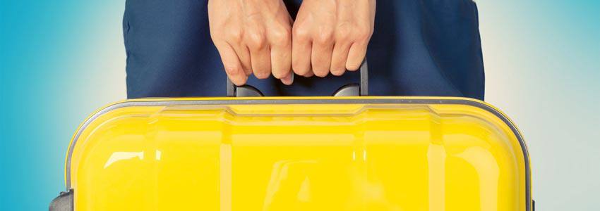 A person holding a suitcase with both arms